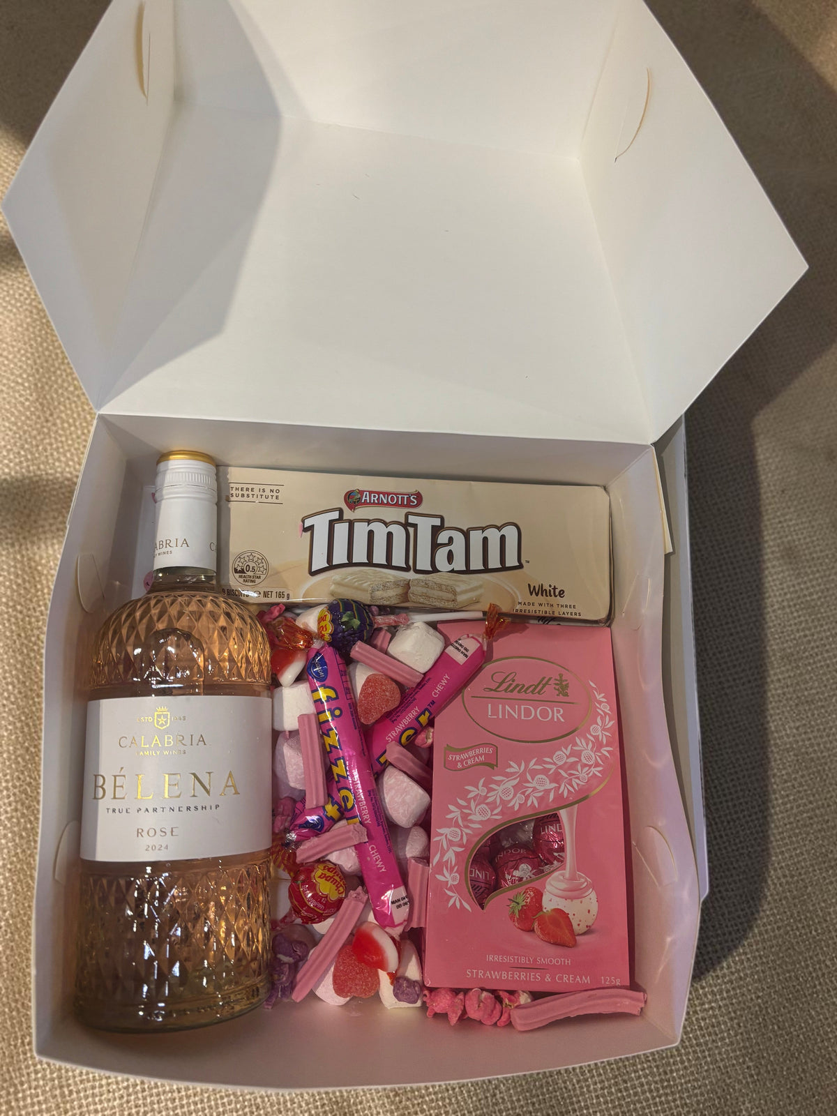 Donut Bouquet Canberra Blushing Rose Hamper with Calabria Rosé, Lindt chocolates, white Tim Tams, and pink lollies.