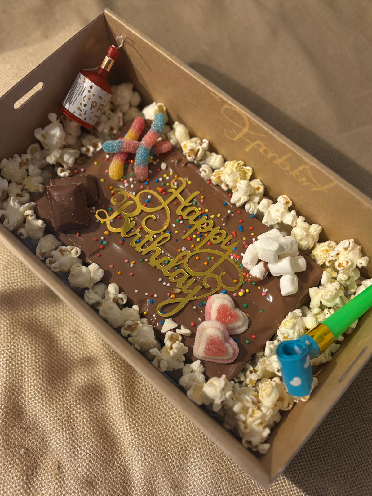 Donut Bouquet Canberra gluten free birthday brownie block topped with popcorn, chocolates, lollies, and sprinkles.