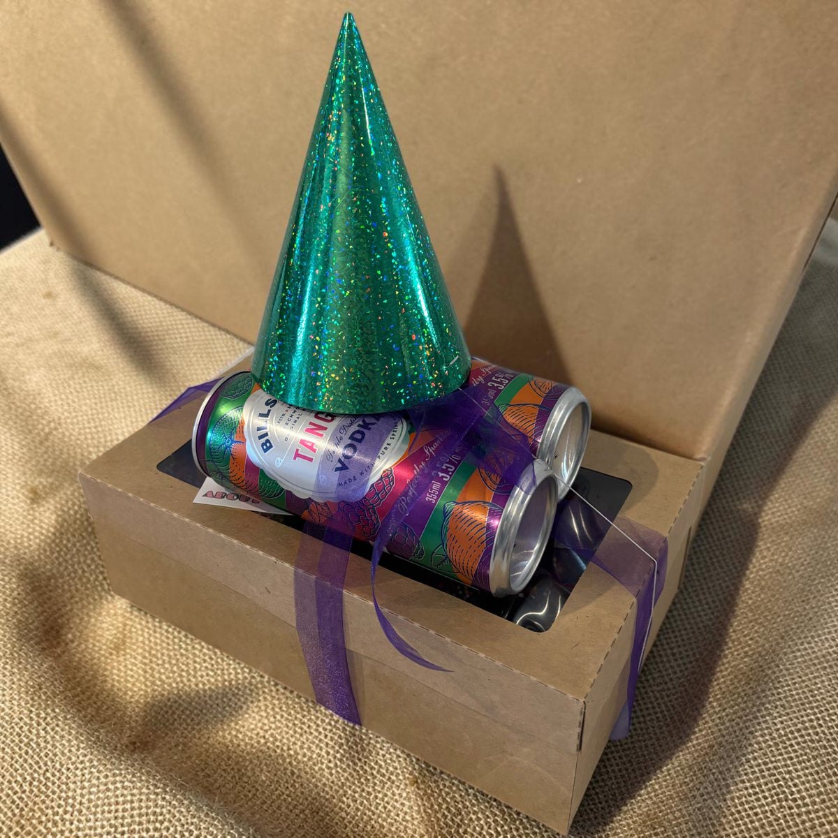 Donut Bouquet Canberra gluten free birthday brownie block gift box topped with a green glitter party hat and cans.