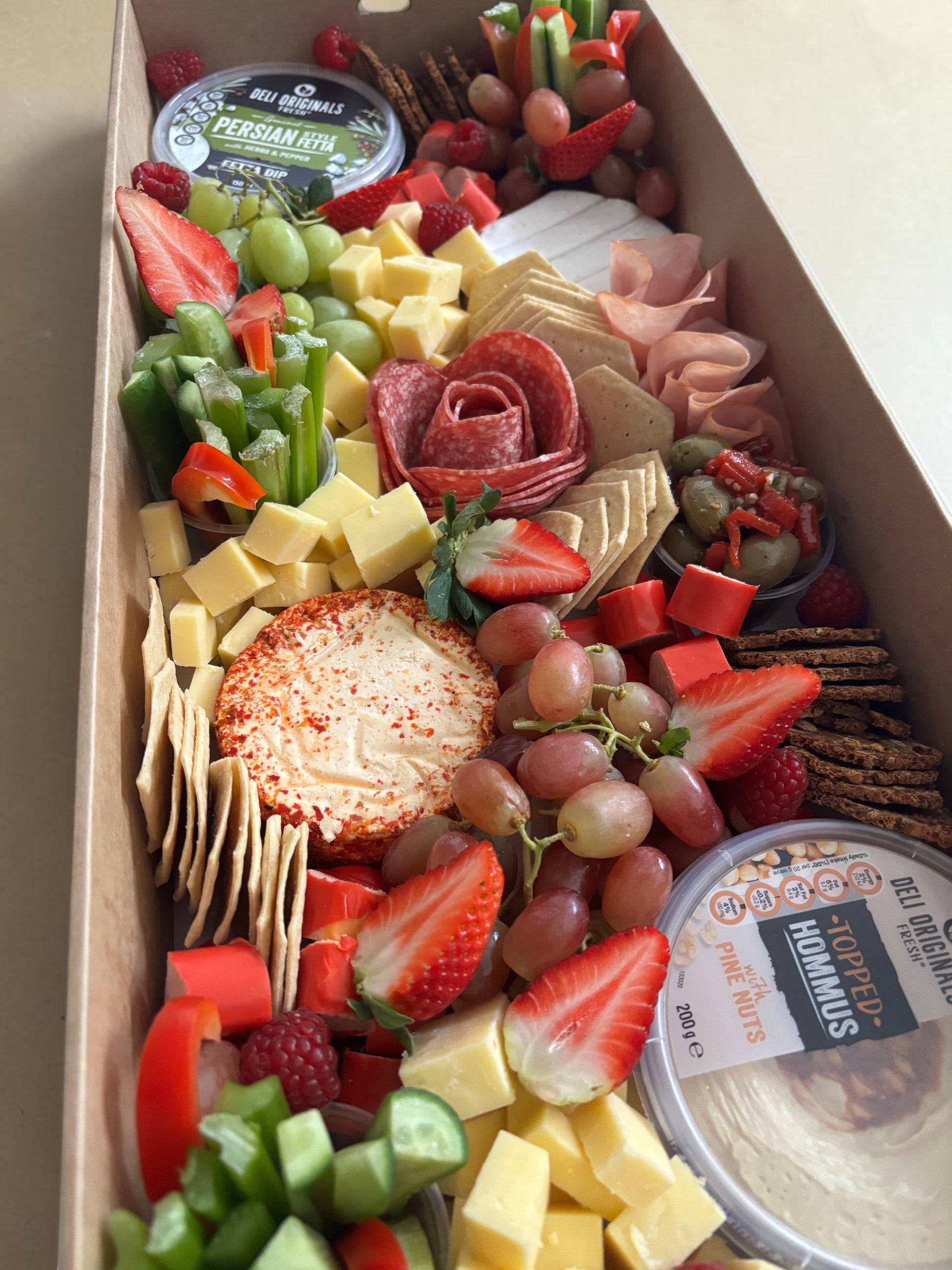Donut Bouquet Canberra grazing box filled with cheese, sliced meats, fresh strawberries, olives, and crackers.