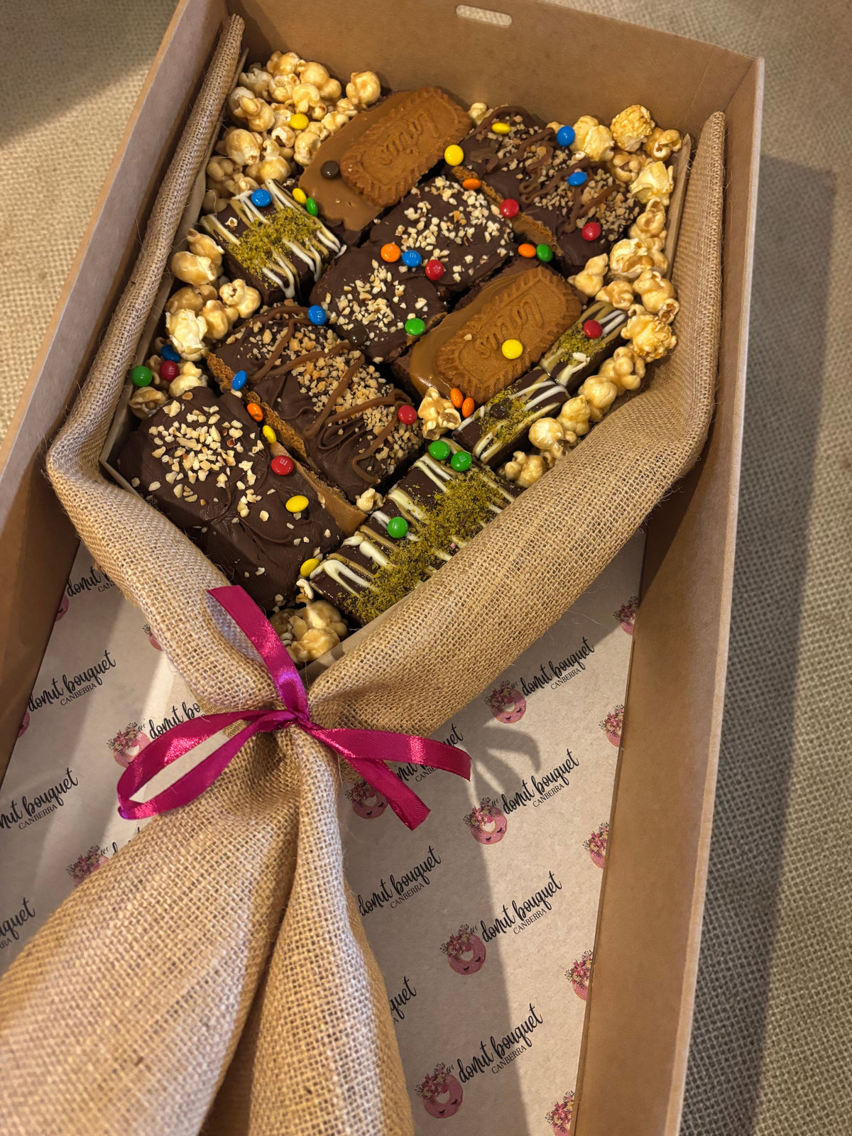 Donut Bouquet Canberra large loaded brownie bouquet gift box with chocolates, M&Ms, and popcorn in a hessian wrap.