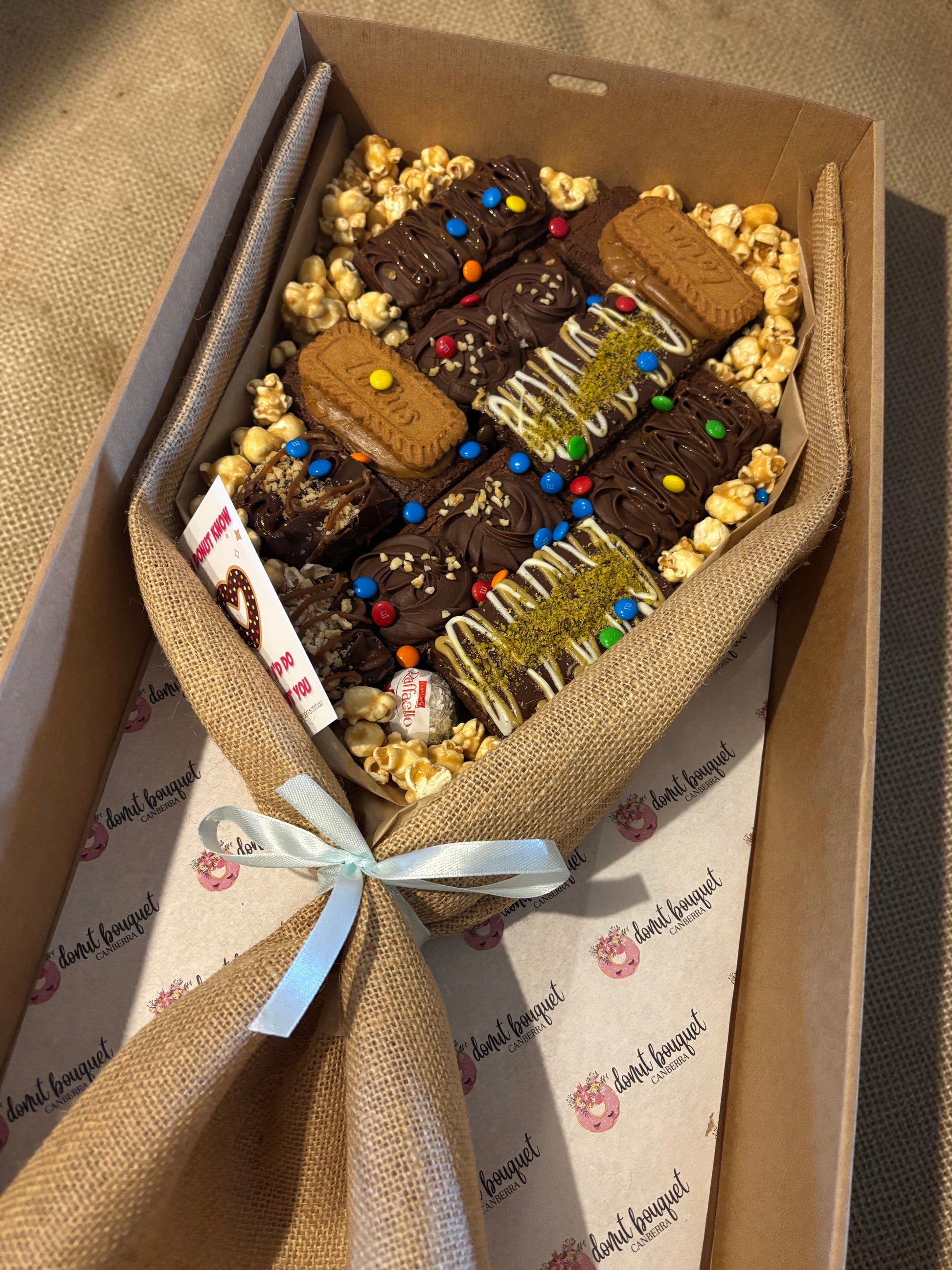 Donut Bouquet Canberra large loaded brownie bouquet gift box with chocolates, M&Ms, and popcorn in a hessian wrap.