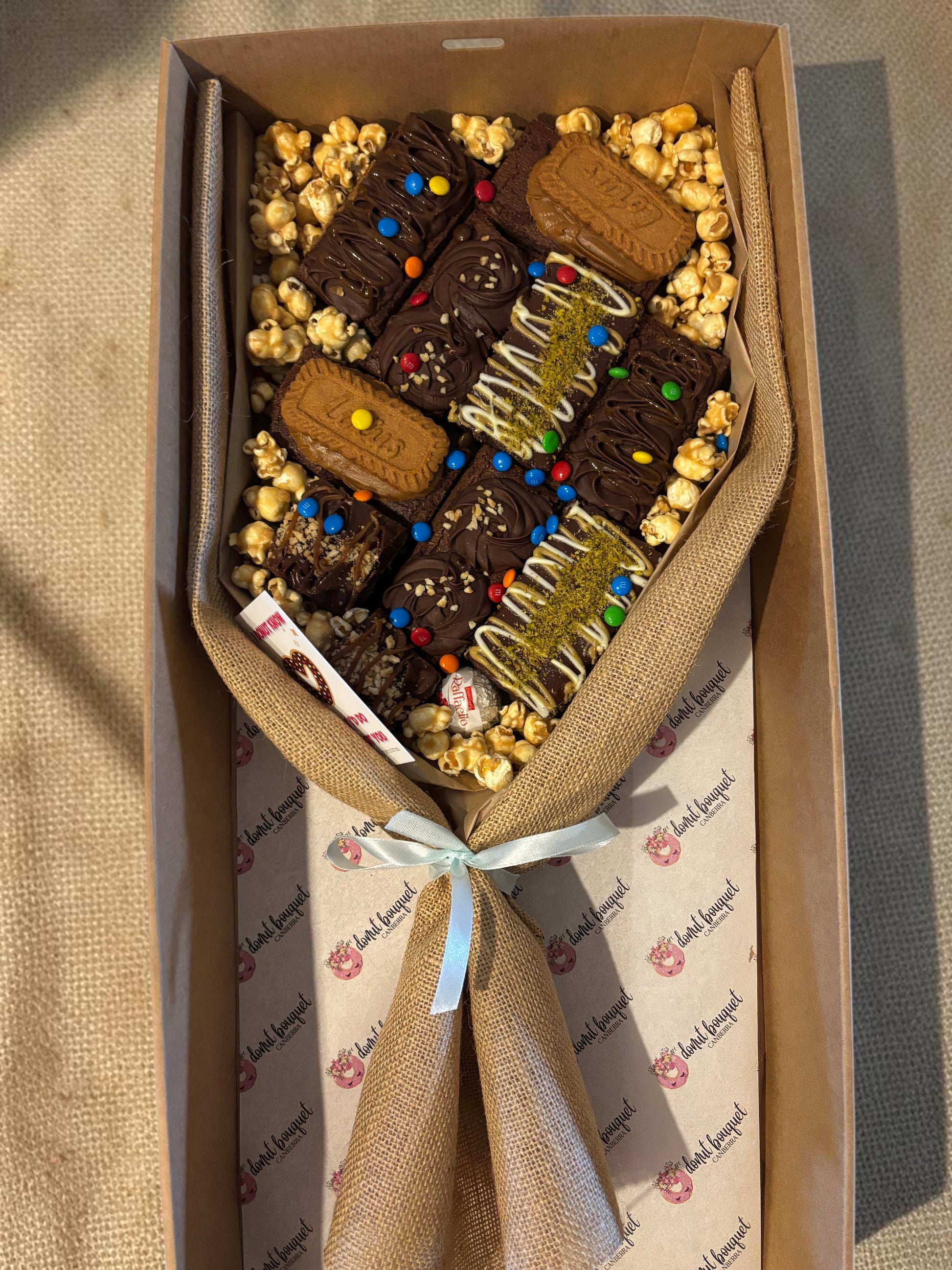 Donut Bouquet Canberra large loaded brownie bouquet gift box with chocolates, M&Ms, and popcorn in a hessian wrap.