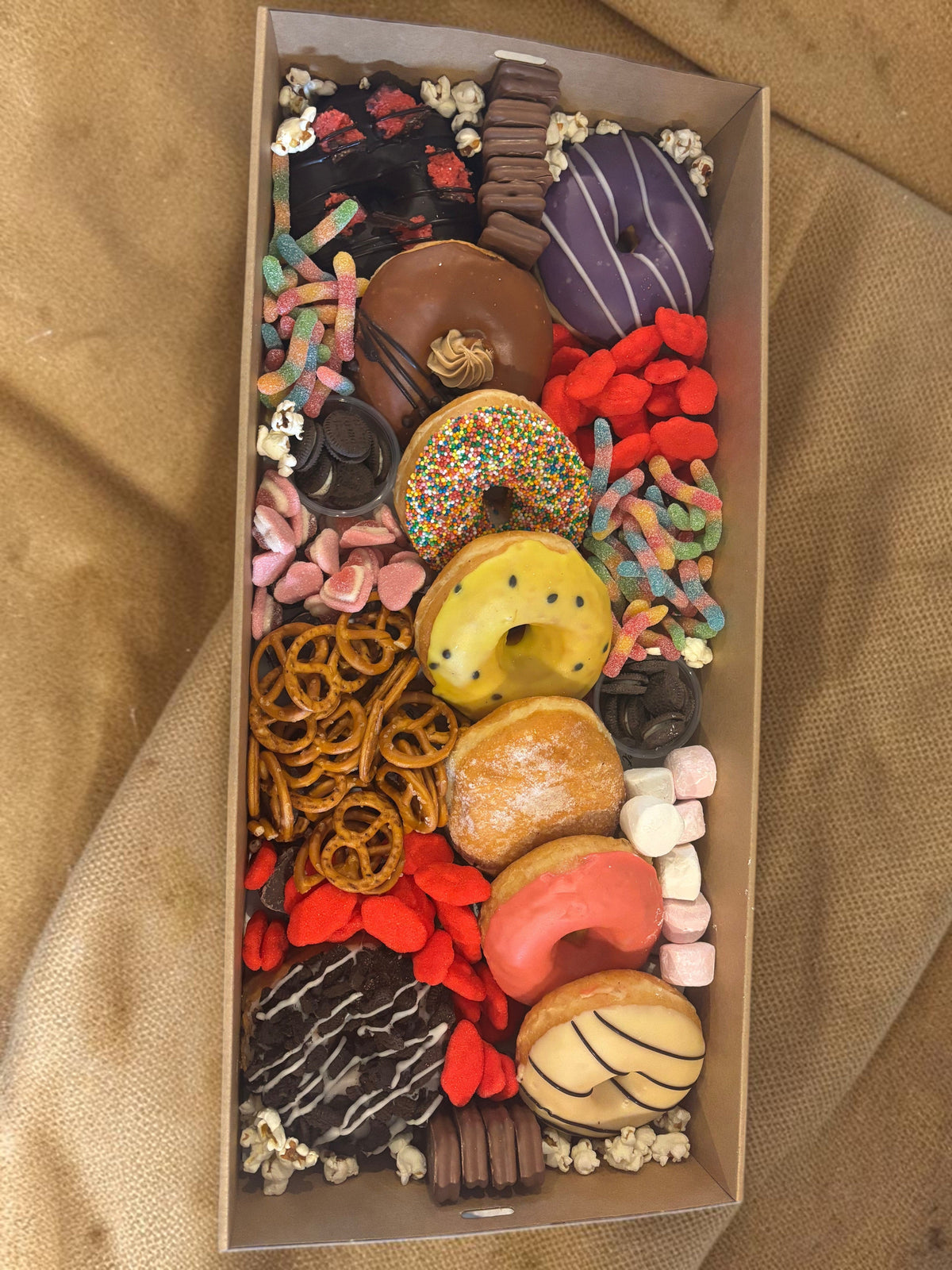 Donut Bouquet Canberra sweets grazing box filled with assorted donuts, pretzels, lollies, Oreos, and Tim Tams.