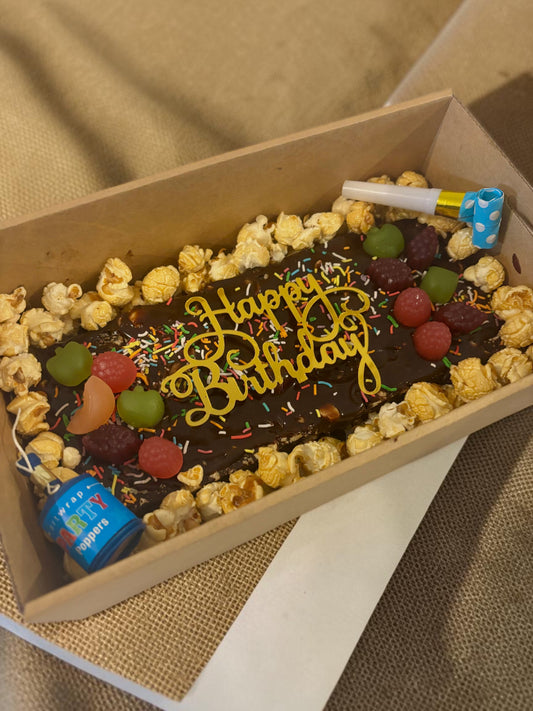 Donut Bouquet Canberra vegan birthday brownie block topped with chocolate, popcorn, lollies, and Happy Birthday sign